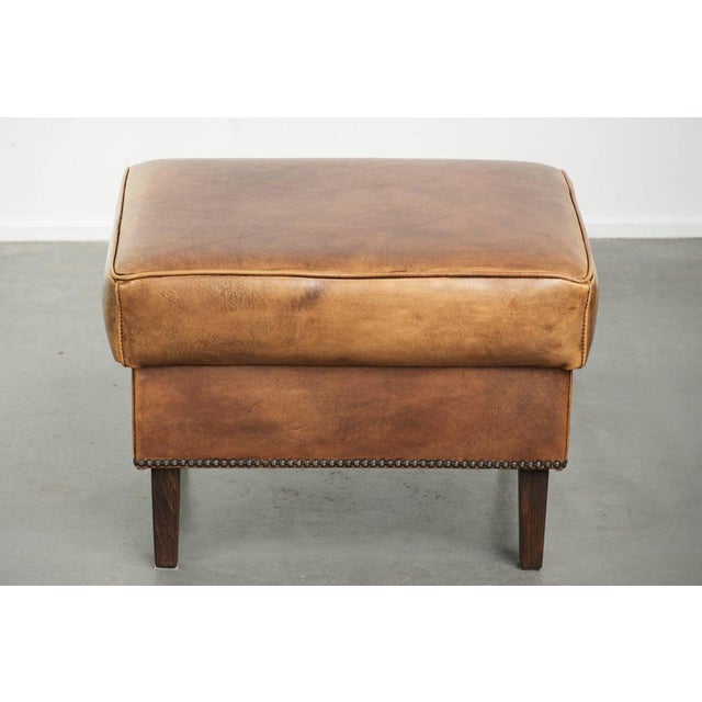 Characterful cowhide leather ottoman with a beautiful patina, finished with decorative nails. : This characterful cowhide...