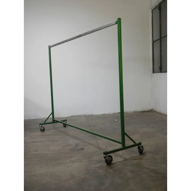 Square iron tube, painted green, with functioning wheels.