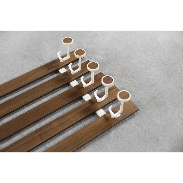 This modernist coat rack was made in Denmark during the 1950s. It was finished with teak wood in a warm shade of brown. It...