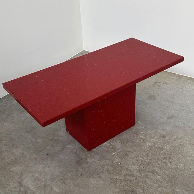 A striking vintage italian red granite coffee table, dating from the 1980s, with a bold architectural design and an...