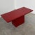 A striking vintage italian red granite coffee table, dating from the 1980s, with a bold architectural design and an...