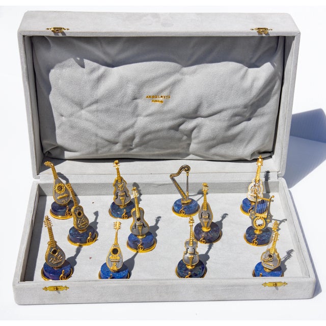 Handmade set of 12 gilt silver and lapis lazuli place card holder. Each a different stringed instrument. In the original...