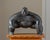 A monumental cast bronze figurative sculpture depicting a crouching sumo wrestler, signed and dated "YURI 05." Beautifully...