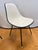 A striking set of four vintage Herman Miller molded shell side chairs featuring original white upholstery with contrasting...