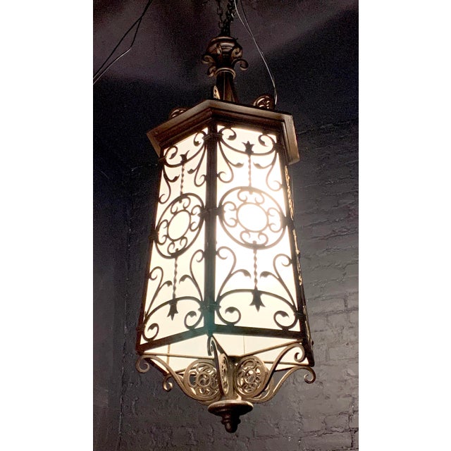 C. 1920's Spanish Revival hexagonal form hanging lantern having decorative metal frame. Shade is ornamented with scrolling...