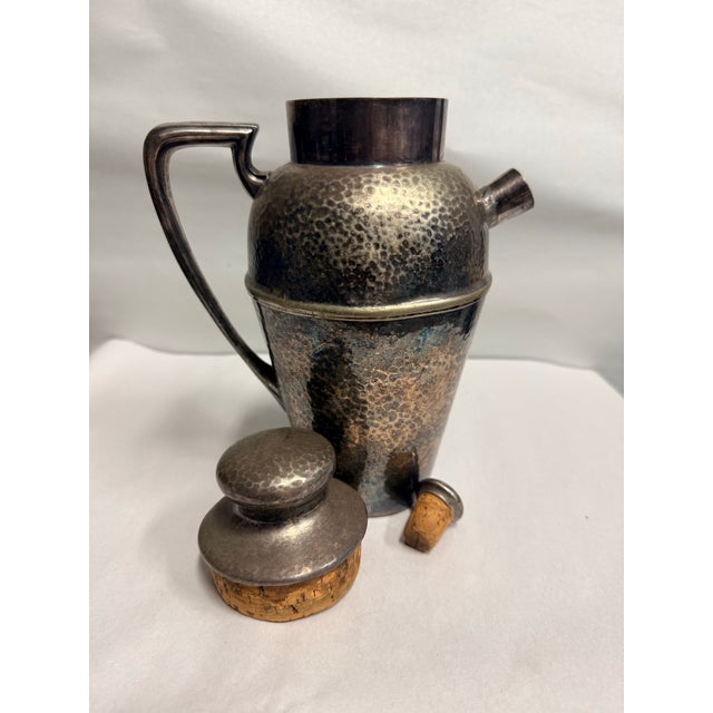 This is Bernard Rice's Sons Apollo EPNS hammered silver-plated cocktail shaker features a classic Art Deco design....