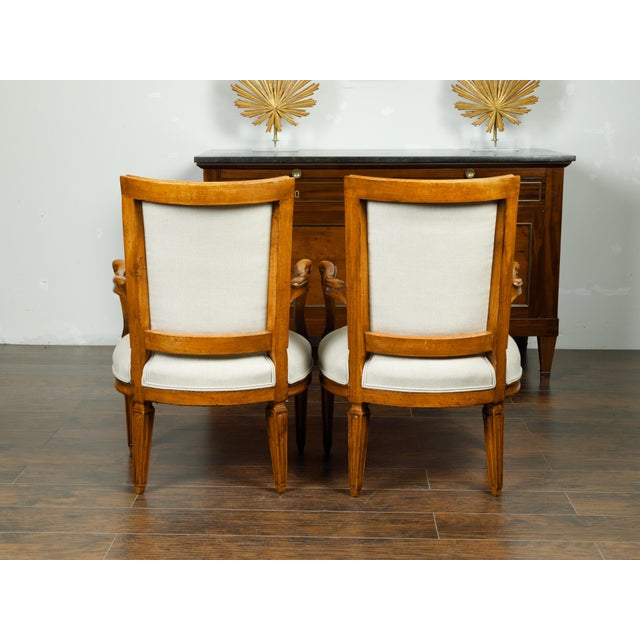 A pair of Italian walnut armchairs from the mid 19th century, with tapered legs and new upholstery. Created in Italy...