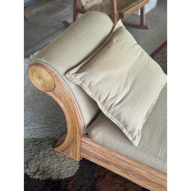 1970s chaise lounge with a sculptural scroll arm and reed-wrapped construction. The frame is composed of tightly bundled...