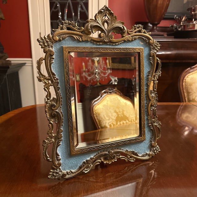 Antique ornate Louis XV style vanity mirror with easel back. Reticulated embossed frame with floral and foliate motives...