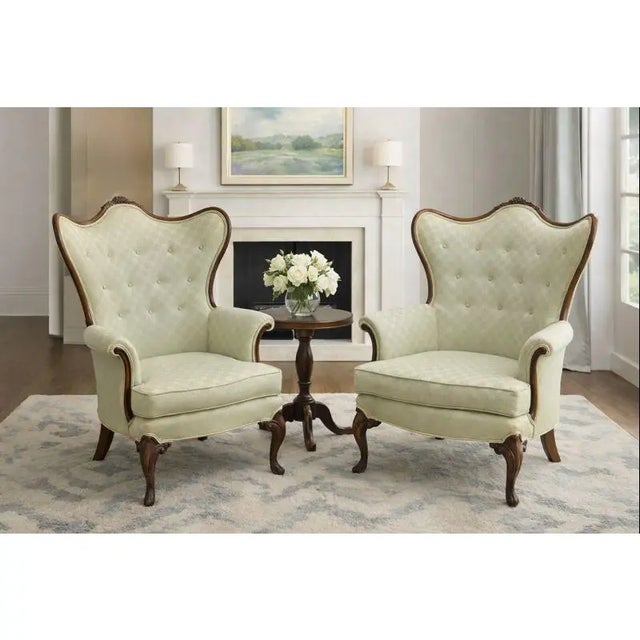 Vintage French Louis XV style carved wood wingback bergère chairs featuring dramatic serpentine backs, exposed carved wood...