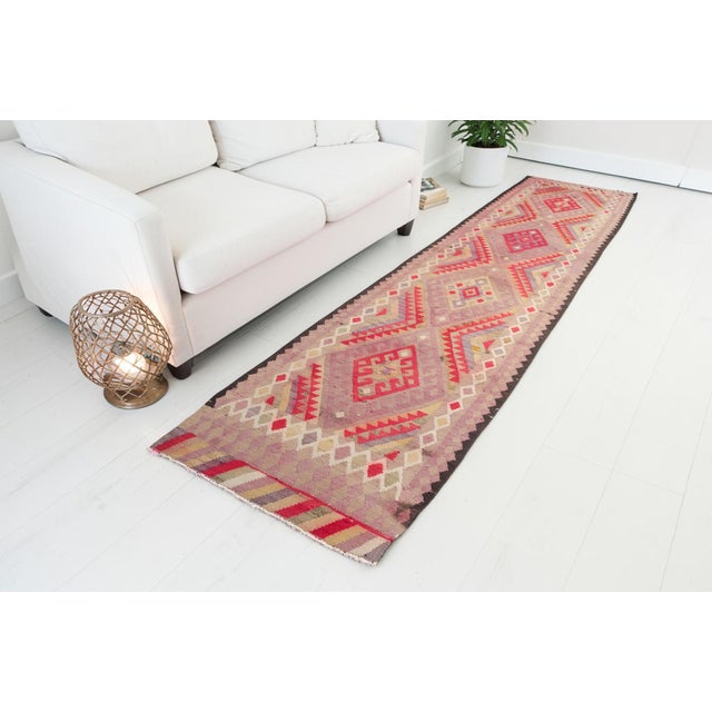 This is a vintage Turkish Oushak rug from the Mid 20th Century. The piece was hand-knotted.