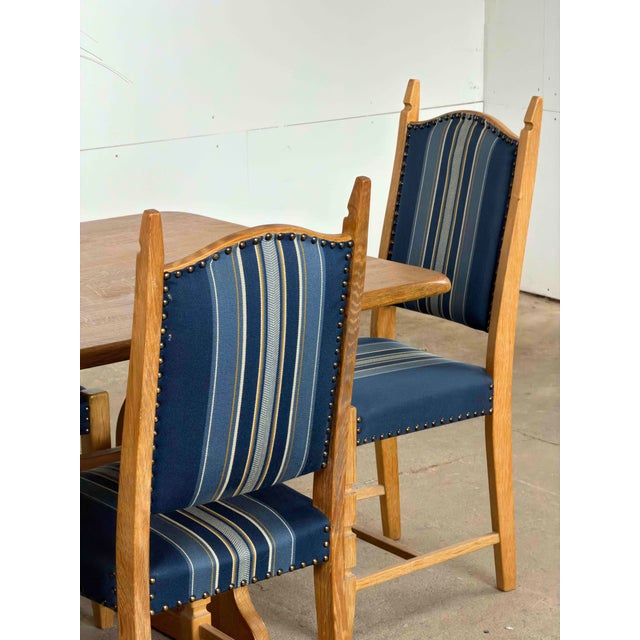 This set of eight dining chairs in style of Henning Kjærnulf. Each chair is constructed in solid oak, with the back...