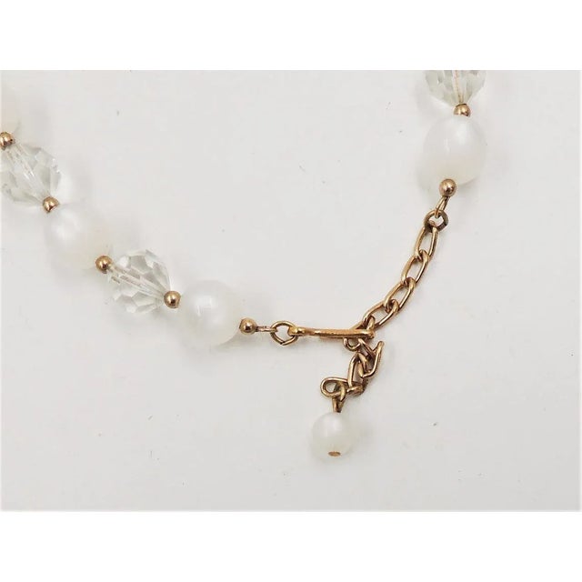 This is part of Chairish’s Costume Jewelry assortment. Early 1960s goldtone cut glass and white "moonglow" faux-moonstone...