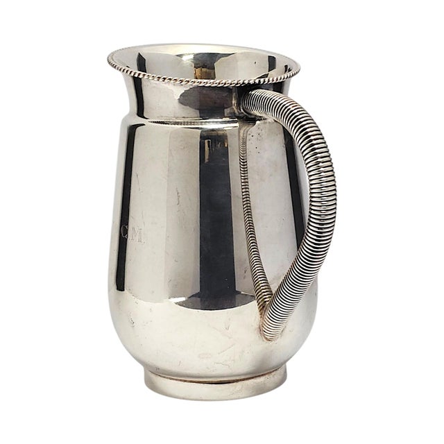 A mid-20th-century Brazilian Prata Régia 90 silver-plated water or beverage pitcher, formed with a tapered bulbous body,...