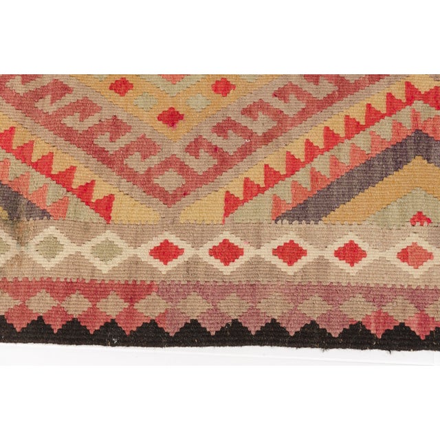This is a vintage Turkish Oushak rug from the Mid 20th Century. The piece was hand-knotted.