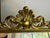 A glamorous mid-century vanity mirror framed in gilt cast metal. Open Rococo scrollwork, curling acanthus leaves and a...