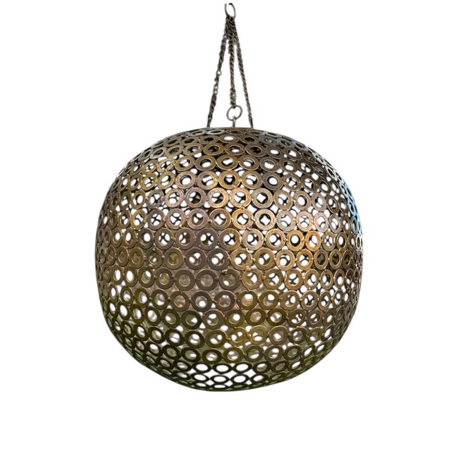 A pair of handmade sculptural metal spheres constructed from welded steel washers and finished in a warm brass tone. Each...