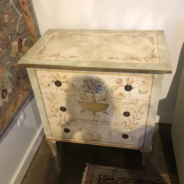 Hand painted three drawer chest in distressed ivory, pale green and gold colors with urn and floral design on front, top...