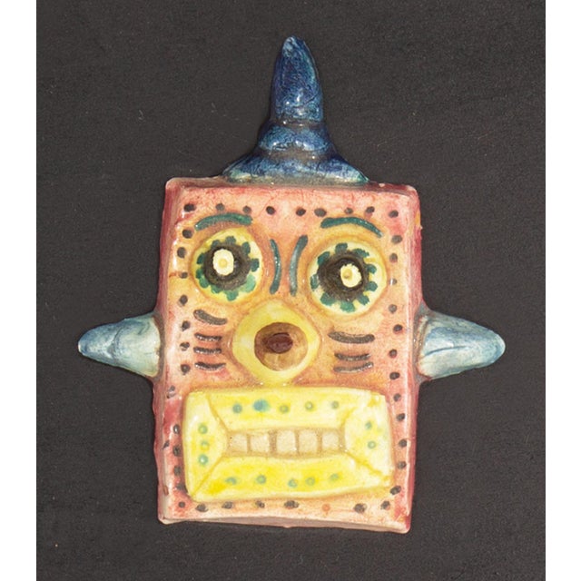 A 1970s ceramic tile by the American artist Mark Bulwinkle (born 1946). This ceramic piece depicts the face of a robot...