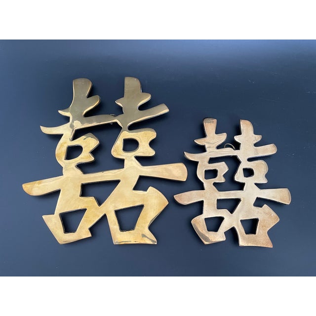 A vintage set of brass trivets in the form of the Chinese Double Happiness symbol, a traditional motif associated with...