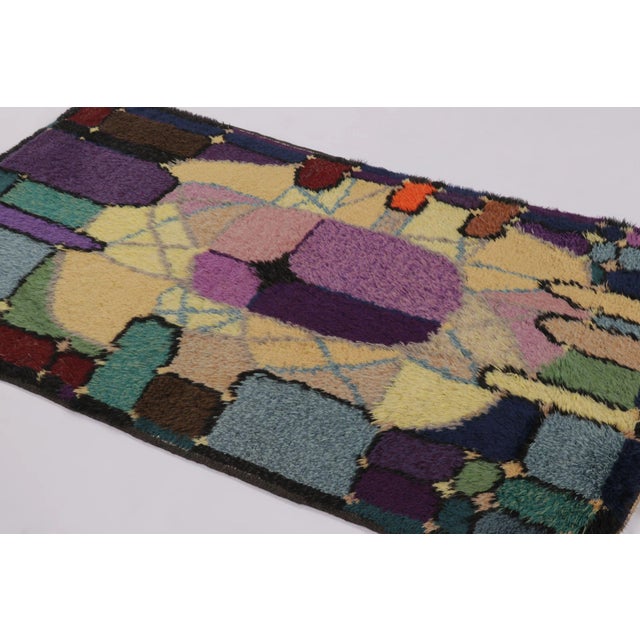 Hand-knotted in lush, high-pile wool in Sweden circa 1960-1970, this 4x6 vintage Swedish Rya rug is a bold new addition to...