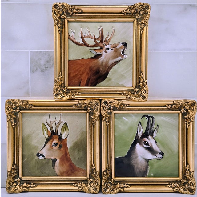 Striking set of three hand-painted porcelain animal plaques depicting a roaring stag, chamois, and antelope, each mounted...