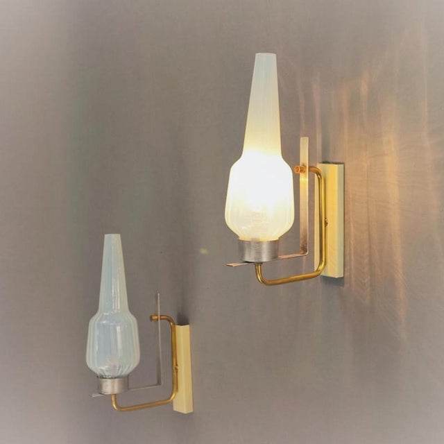 A pair of vintage wall lamps with brass, brushed aluminum, and cream-white lacquered metal frames and opalescent Murano...