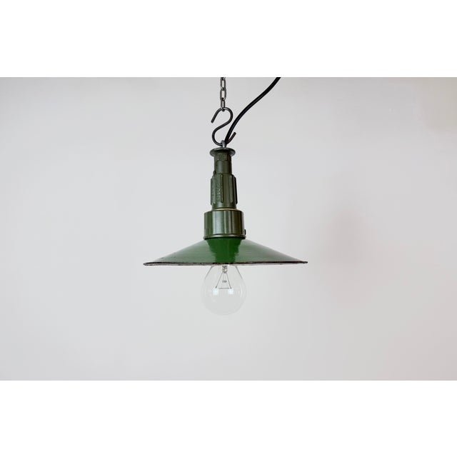 Industrial green enamel pendant light made in Poland during the 1960s. White enamel inside the shade. Green cast aluminium...