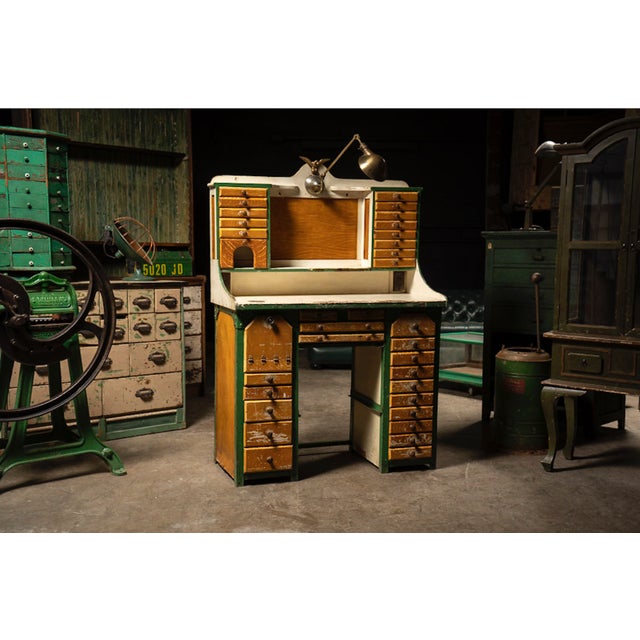 Antique watchmaker's or jeweler's workbench featuring an extensive arrangement of small parts drawers, storage...