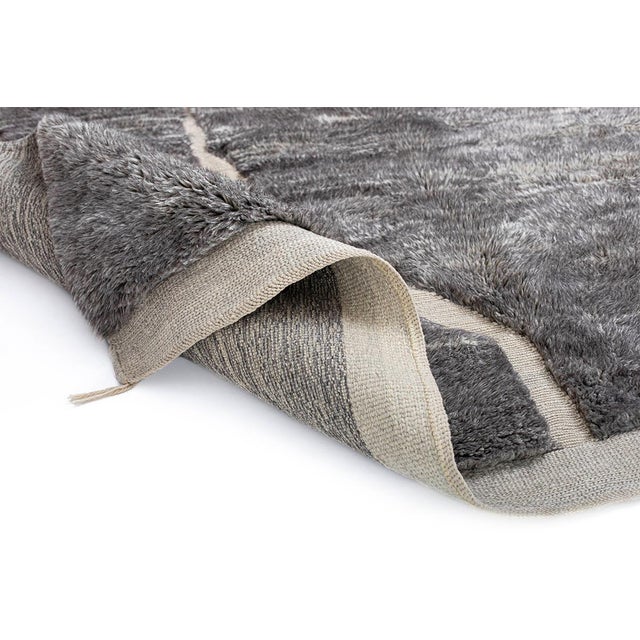 Artistic hand-knotted wool rug in deep Charcoal Gray, Cool Gray, and soft Ivory, showcasing an abstract, textured...