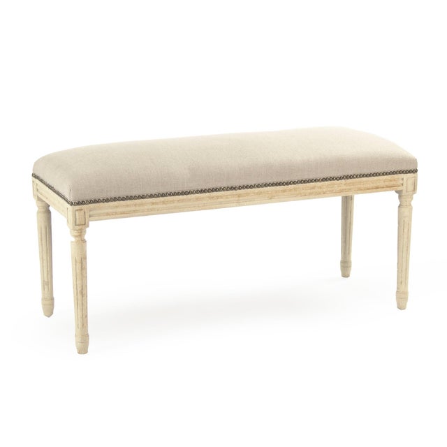 The Lille Bench from Zentique features natural linen upholstery accented with a line of bronze nailhead trim along the...