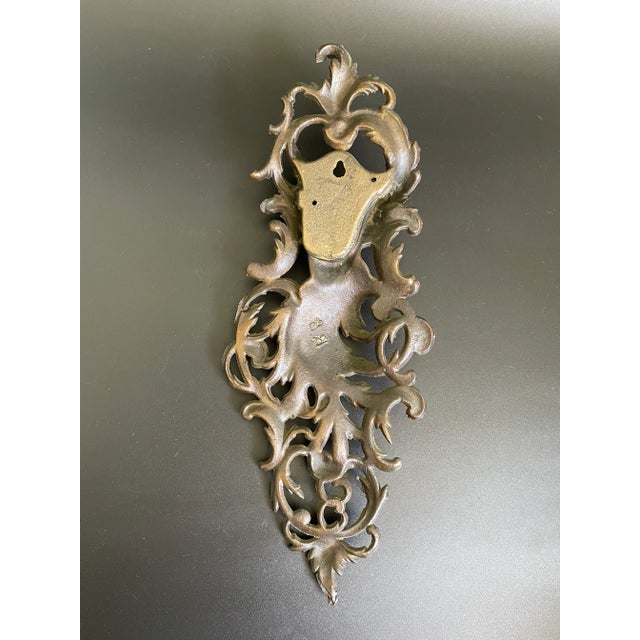 This Rococo Revival bronze match holder from the late Victorian Era features a female figure nestled within scrolling...