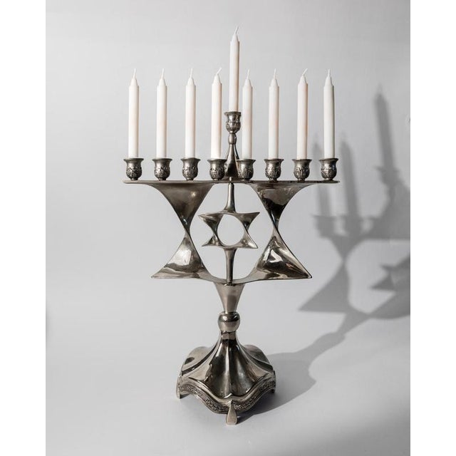 This vintage silver-plated Menorah from the 1960s is a beautiful example of Mid Century Judaica design. Crafted with...