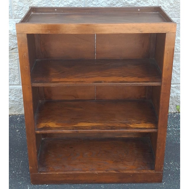 A Mid Century Stained Pine Low Bookcase Measures 24" in width, 12.75" in depth and 30.75' in height