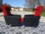 Red and black faux leather and fabric armchairs with splayed legs. Black faux leather armrests. Seat and back upholstered...