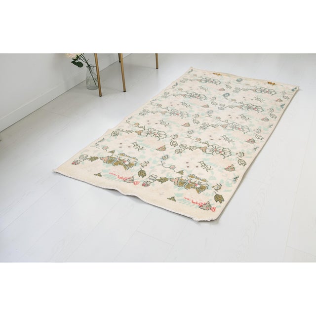 This is a vintage Turkish Oushak rug from the Mid 20th Century. The piece was hand-knotted.