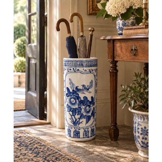 A classic blue and white porcelain umbrella stand in the chinoiserie tradition, featuring finely rendered birds among...