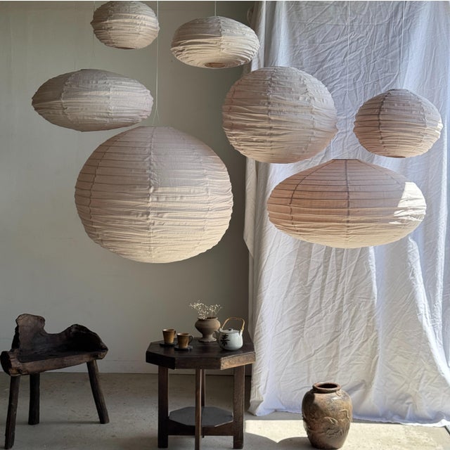 Small, round, pale pink Japanese-style rattan and natural linen pendant light. Beautifully handcrafted: natural rattan and...