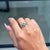 This floral cluster ring showcases 0.69 carats of natural emeralds, set in 14k yellow gold. The oval-cut emeralds...