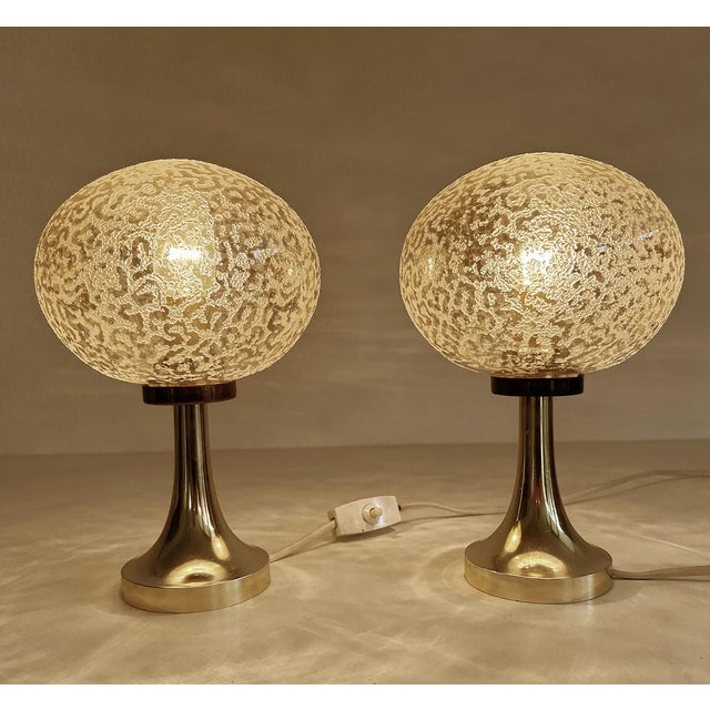 Pair of vintage space age table lamps featuring an amber tint cocoon like globe glass shade wiith sprinkled structure on...
