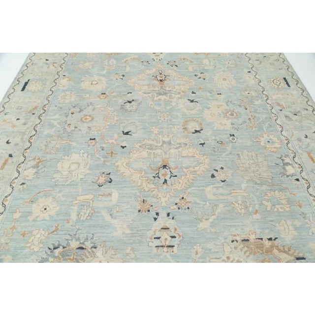 This Oushak Hand-Knotted Wool Teal Area Rug celebrated for its understated elegance, is greatly influenced by original...