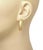 The product is a pair of curved diamond bar earrings made of 18k yellow gold. These huggie earrings are part of fine...