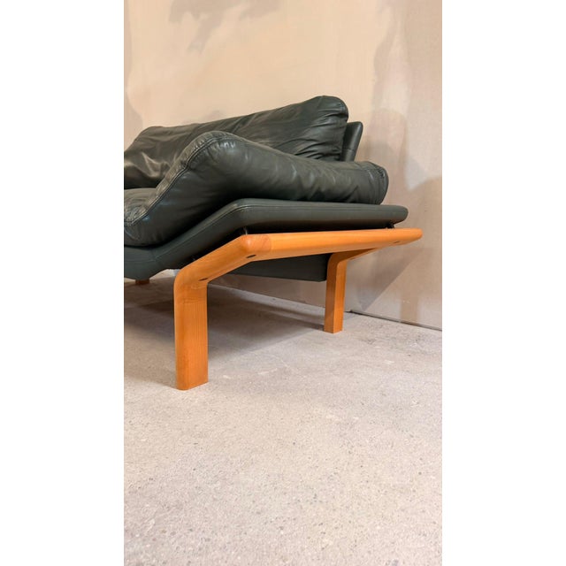 Danish 2-seater sofa by Komfort in Scandinavian design. The teak frame and dark green leather upholstery give the sofa an...