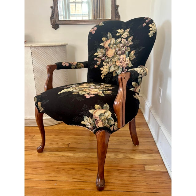A pretty French Louis XV style bergere chair, handsomely upholstered in black with pomegranates, grapes, and florals....
