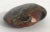 Hand polished agate onyx stone paperweight in black, brown, and red intricate layered patterns Measures: length 4.75...