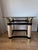 Elegant postmodern / Hollywood Regency style coffee table featuring a square smoked glass top with rounded corners and a...