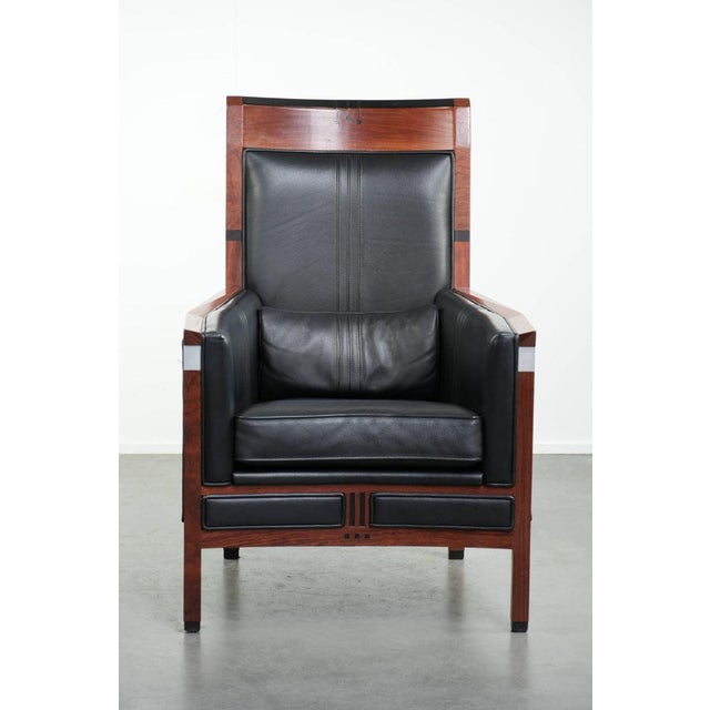 Black cowhide leather Schuitema Art Deco design armchair with a high back and beautiful woodwork from the Decoforma...