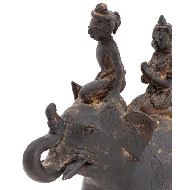 Thai Two Figures Riding Atop an Elephant Patinated Metal Sculpture, probably 19th century. 6.75" H x 5.5" W x 2.25" D....