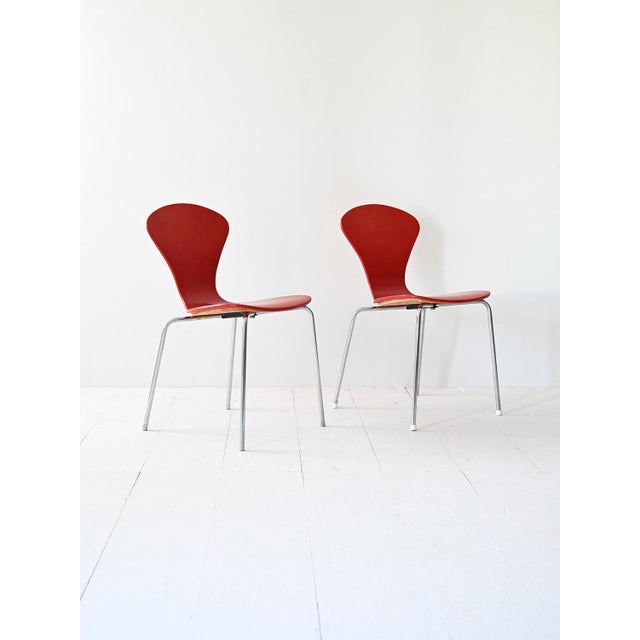 A pair of original Lennart Bender chairs, featuring a distinctive design with tubular metal legs and a red painted wooden...