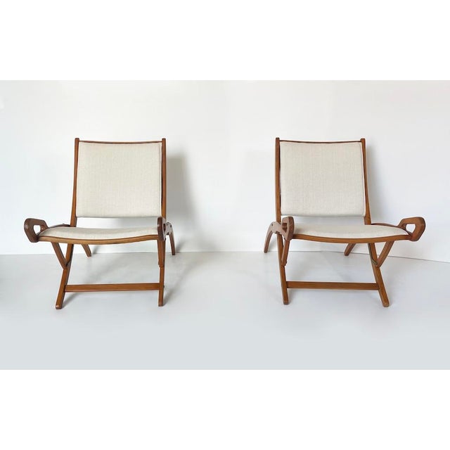 A refined pair of folding armchairs designed by gio ponti, made in 1958 by fratelli reguitti and published in "novità,"...